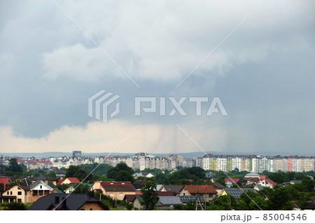 Landscape of dark clouds forming on stormy sky during thunderstorm over city rural area. 85004546