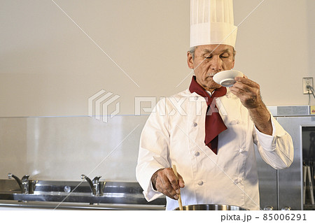 飲食店の厨房でコック服を着たシニア男性が料理を作る 飲食店の厨房でコック服を着たシニア男性が料理を作る 85006291