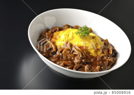 たっぷりのハヤシソースがかかったオムライスを黒背景で撮影 85008916