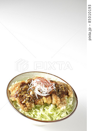 白髪葱、糸唐辛子、千切りキャベツ、油淋鶏丼を白背景で撮影 85010193