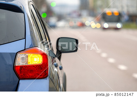 Closeup of rear headlight of new clean car parked on a city street side. 85012147