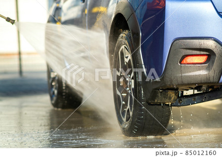 Closeup of male driver washing his car with contactless high pressure water jet in self service car wash. 85012160
