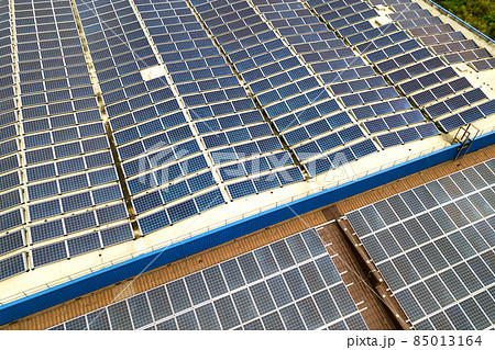 Aerial view of solar power plant with blue photovoltaic panels mounted of industrial building roof. Aerial view of solar power plant with blue photovoltaic panels mounted of industrial building roof. 85013164