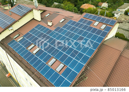 Aerial view of solar power plant with blue photovoltaic panels mounted of apartment building roof. Aerial view of solar power plant with blue photovoltaic panels mounted of apartment building roof. 85013166
