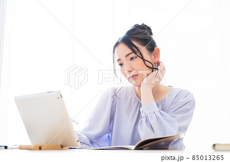 画面を見て難しそうな表情の女性 画面を見て難しそうな表情の女性 85013265