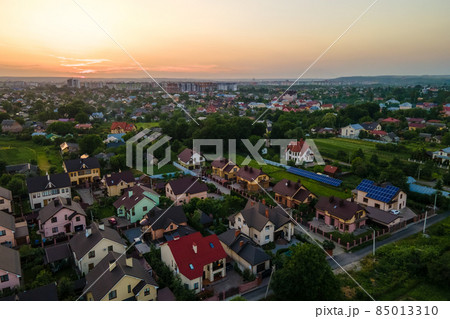 Aerial view of residential houses in suburban rural area at sunset. Aerial view of residential houses in suburban rural area at sunset. 85013310