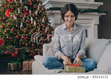 Happy Italian female preparing for Xmas at home, wrapping and packing christmas gift 85014172