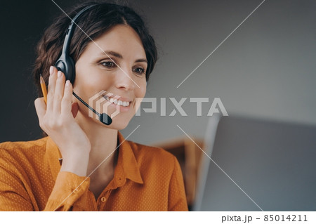 Pleasant woman Spanish speaking call center employee in wireless headset talking with client 85014211