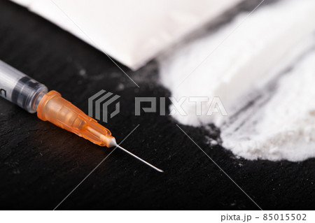 Cocaine or other illegal drugs, white powder, money, pills, syringe on black background. Cocaine or other illegal drugs, white powder, money, pills, syringe on black background. 85015502