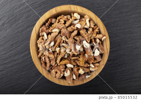 Walnut in wooden bowl on black background with copy space. Walnut in wooden bowl on black background with copy space. 85015532