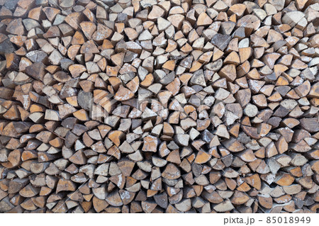 Natural wooden background - closeup of chopped firewood. Firewood stacked and prepared for winter 85018949