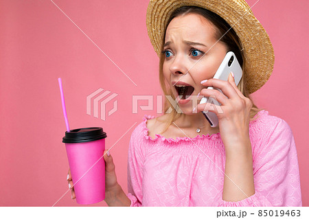 Portrait of attractive shocked amazed emotional young blonde woman wearing pink crop blouse and Portrait of attractive shocked amazed emotional young blonde woman wearing pink crop blouse and 85019463