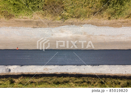 Aerial view of new road construction with newly layed black asphalt lane. 85019820