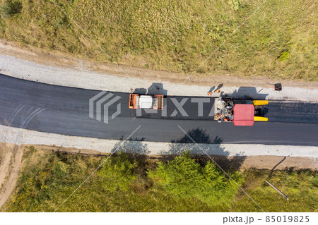 Aerial view of new road construction with asphalt laying machinery at work. 85019825