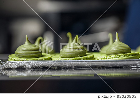 Process of making fresh handmade macaroons in restaurant kitchen. Colourful macaroons cookies on baking trays 85020905
