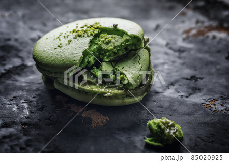 Macro close up of green smashed macaroon on grey clay background 85020925