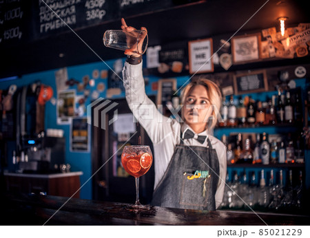 Girl bartender concocts a cocktail on the beerhall Girl bartender concocts a cocktail on the beerhall 85021229