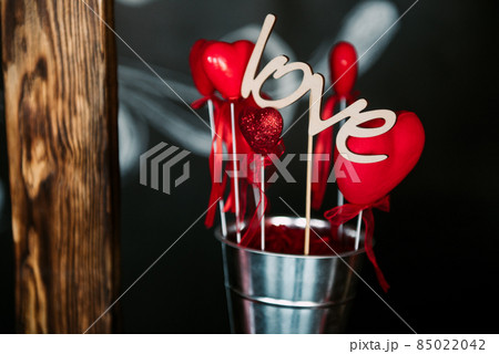 Valentine day love beautiful. Heart gaarland hanging on branch of tree on, photo zone with photo props and kissing booth 85022042