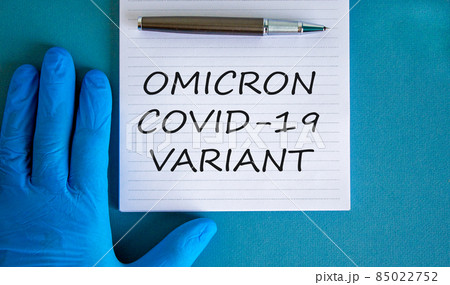 New covid-19 omicron variant strain symbol. Hand in blue glove with white note. Concept words Omicron covid-19 variant. Metalic pen. Medical and COVID-19 omicron variant strain concept. Copy space. 85022752