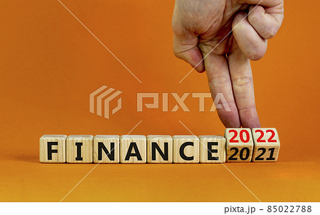 2022 finance and new year symbol. Businessman turns wooden cubes, changes words 'finance 2021' to 'finance 2022'. Beautiful orange background, copy space. Business, 2022 finance and new year concept. 85022788
