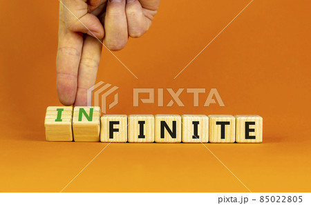 Finite or infinite symbol. Businessman turns wooden cubes and changes the word 'finite' to 'infinite'. Beautiful orange table, orange background. Business, finite or infinite concept. Copy space. Finite or infinite symbol. Businessman turns wooden cubes and changes the word 'finite' to 'infinite'. Beautiful orange table, orange background. Business, finite or infinite concept. Copy space. 85022805