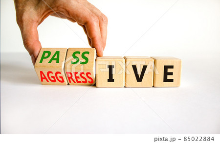 Passive or aggressive symbol. Businessman turns wooden cubes and changes the word passive to aggressive. Beautiful white background, copy space. Business, psychological passive aggressive concept. Passive or aggressive symbol. Businessman turns wooden cubes and changes the word passive to aggressive. Beautiful white background, copy space. Business, psychological passive aggressive concept. 85022884