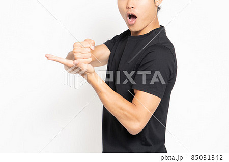 白い背景の前に立って納得したポーズをする黒いTシャツを着ている男性 85031342