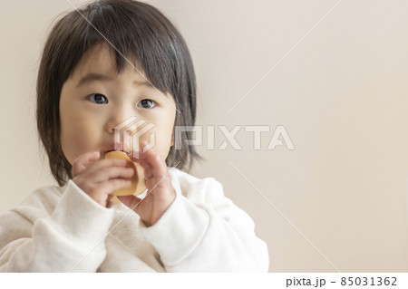 小さいパンを自分で食べる赤ちゃん（1歳5か月、女の子、日本人） 85031362