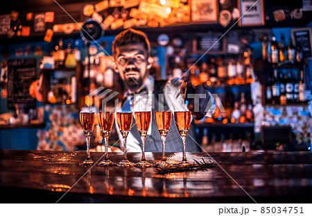 Barman concocts a cocktail at the bar Barman concocts a cocktail at the bar 85034751