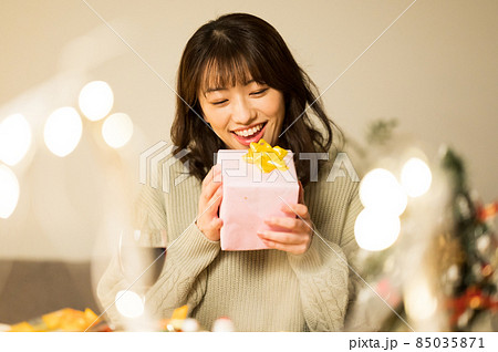 プレゼントを開けようとする女性 プレゼントを開けようとする女性 85035871