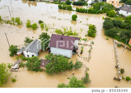 Aerial view of flooded house with dirty water all around it. 85036340