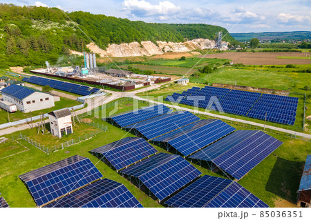 Aerial view of electrical power plant with rows of solar photovoltaic panels for producing clean ecological electric energy at industrial area. Renewable electricity with zero emission concept. Aerial view of electrical power plant with rows of solar photovoltaic panels for producing clean ecological electric energy at industrial area. Renewable electricity with zero emission concept. 85036351