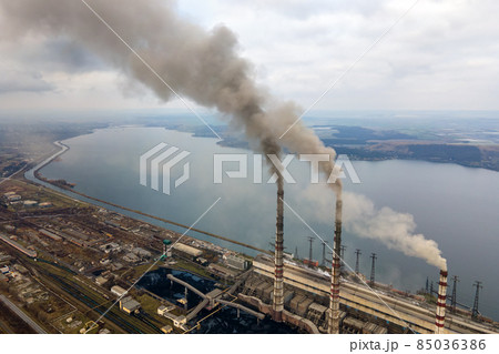 Aerial view of coal power plant high pipes with black smoke moving up polluting atmosphere. 85036386