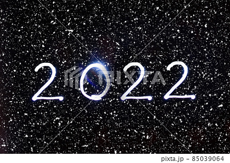 New Year 2022 on a black snowy background. Concept light New Year 2022 on a black snowy background. Concept light 85039064
