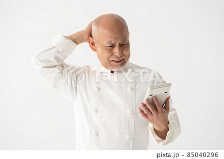 計算機を持つ男性　シェフ　料理人　悩む 85040296