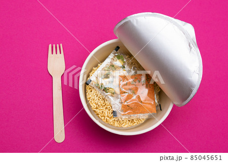 Opened Package with Uncooked Instant Noodles on Pink Background Opened Package with Uncooked Instant Noodles on Pink Background 85045651
