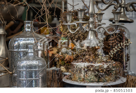 Antique candlestick and Dry plant, Dried flowers, Pine cones with Glass bottle Decorate on wooden table in cafe. Antique candlestick and Dry plant, Dried flowers, Pine cones with Glass bottle Decorate on wooden table in cafe. 85051503