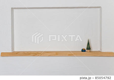 珪藻土を塗ったニッチに飾ってある木製の木と小さなおうち 85054792