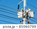 Group of Male Engineer or Electrician working on Crane Bucket over Electrical Pole 85060799