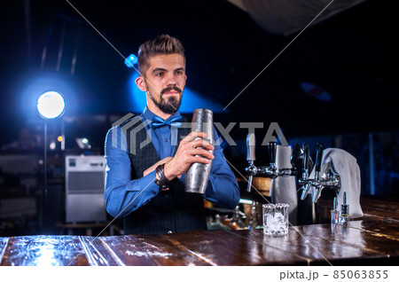 Bearded bartending places the finishing touches on a drink at the nightclub Bearded bartending places the finishing touches on a drink at the nightclub 85063855