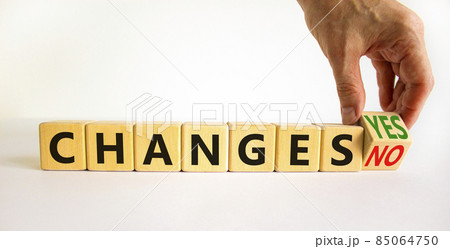 Changes yes or no symbol. Businessman turns a wooden cube and changs words changes no to changes yes. Beautiful white table, white background, copy space. Business and changes yes or no concept. 85064750