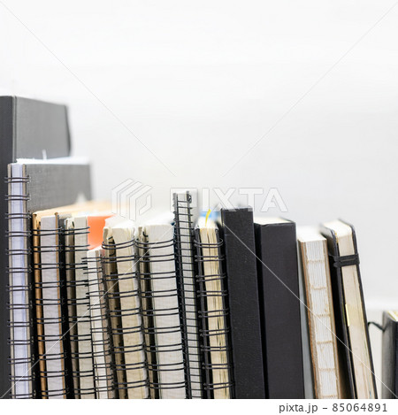 Row of sketchbooks on wooden shelf with copy space on white wall background Row of sketchbooks on wooden shelf with copy space on white wall background 85064891