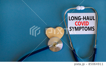 COVID-19 long-haul covid symptoms symbol. White card with words Long-haul covid symptoms. Wooden heart, stethoscope, blue background, copy space. Medical, COVID-19 long-haul covid symptoms concept. COVID-19 long-haul covid symptoms symbol. White card with words Long-haul covid symptoms. Wooden heart, stethoscope, blue background, copy space. Medical, COVID-19 long-haul covid symptoms concept. 85064911