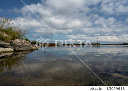 A blue sky with patchy clouds over a calm bay in summertime. From the swedish island oland. 85069618