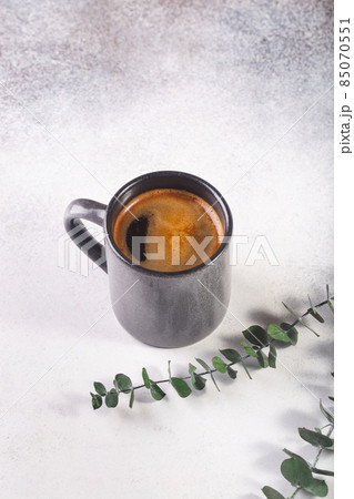 cup of coffee on grey table eucalyptus leaves 85070551
