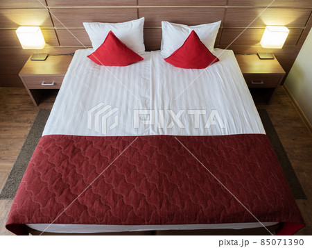 Beautiful bed with red pillows in the room Beautiful bed with red pillows in the room 85071390