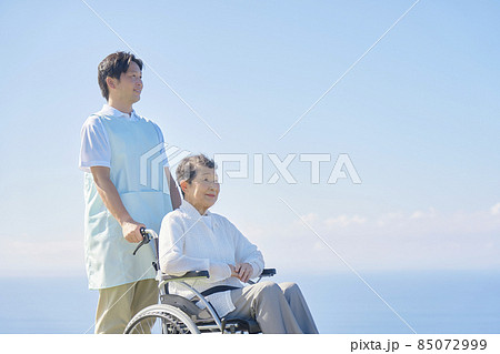 介護士と車椅子に乗る高齢者 屋外 介護士と車椅子に乗る高齢者 屋外 85072999