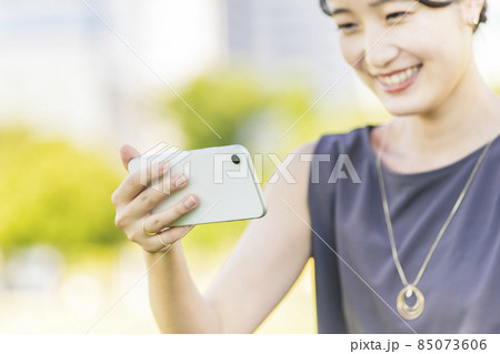 スマートフォンの画面を見る女性 85073606