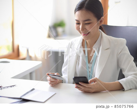Businesswoman uses mobile banking to transfer money 85075766