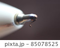 Macro photo of ballpoint pen tip with dark grey background. 85078525